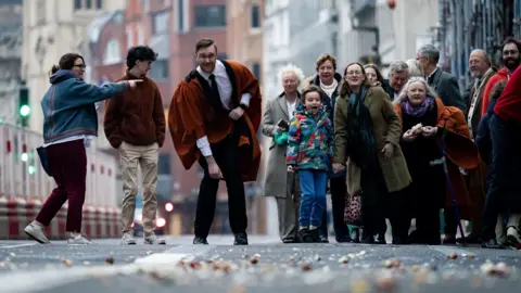 PA Media People take part in rolling hard boiled eggs on Fleet Street outside St Bride's Church