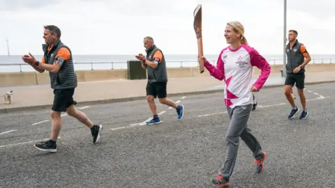 Getty Images Johana Atkinson carries the Queen's baton at Redcar