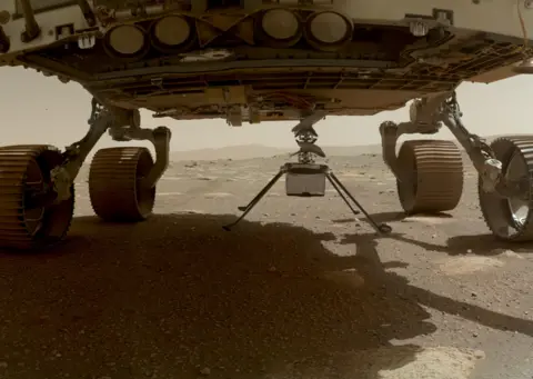 NASA/JPL-Caltech/MSSS Nasa's Ingenuity helicopter can be seen with all four of its legs deployed below the Perseverance rover, on 30 March 2021