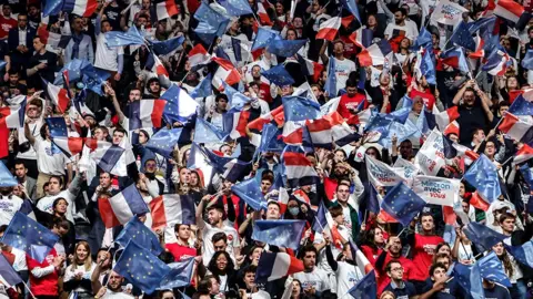 Getty Images A crowd gather at a rally for President Macron