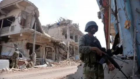 AFP Pakistani soldiers stand guard at a destroyed empty bazaar during a military operation against Taliban militants in the main town of Miranshah in North Waziristan on July 9, 2014.