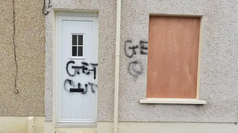 PAcemaker Paint saying Get Out daubed on door in Larne