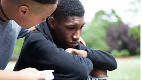 Getty Images upset teenage boy comforted by friend