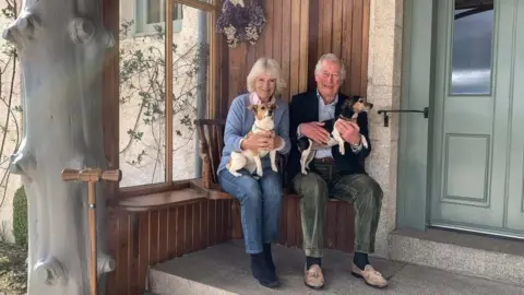 Camila and Prince Charles holding their dogs