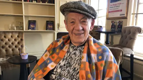 BBC Sir Ian McKellen smiling in a backstage room at the Bristol Hippodrome