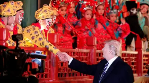 Reuters US President Donald Trump shakes hands with an opera performer in Beijing