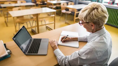 Getty Images teacher marking papers