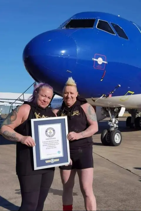 Sue Taylor-Franklin Sue Taylor-Franklin and her wife Sam in front of the plane they pulled for a world record