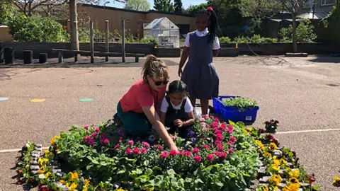 BBC Key worker pupils and staff make a rainbow of flowers