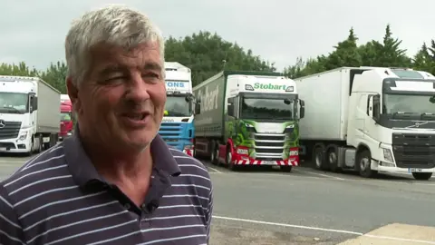 Nick Downing  Nick Downing in front of lorries