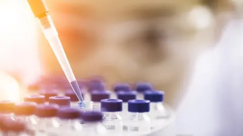 Getty Images Laboratory worker using pipette on sample pots