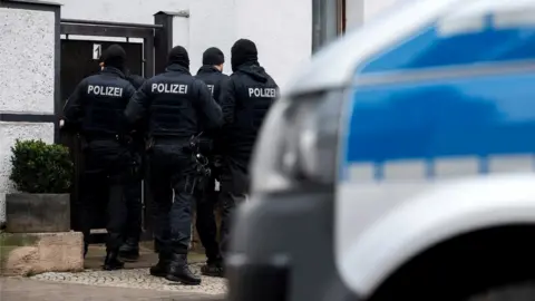 Getty Images Police raid a property in the Vieselbach district of Erfurt, eastern Germany, in connection with the ban of the neo-Nazi group Combat 18, 23 January 2019