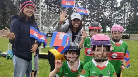 Michael Davitt GAC and Cambodian team Cairde Khmer players pose for a picture holding camogie sticks