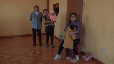 Florence Goupil Cinthia Estrada Bolivar (31) and her 3 year old daughter, in their house accompanied by their relatives