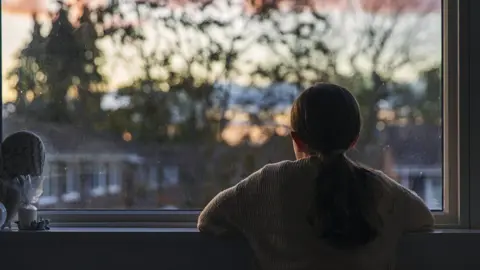 Getty Images girl looking out window