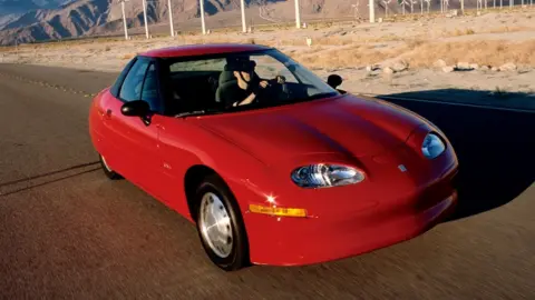 An EV1 electric car parked on a road