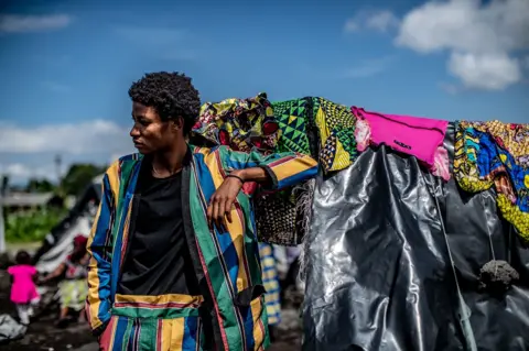 Moses Sawasawa A man poses in a suit with panels of various colours, on Friday 15 April 2022.