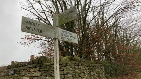 A wooden signpost with the names of Oxfordshire villages