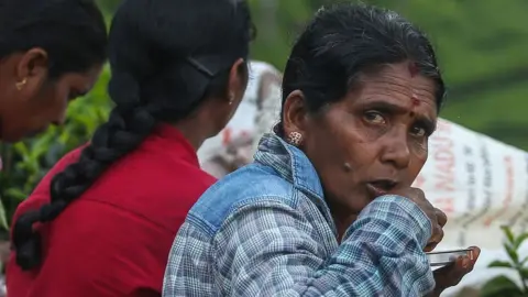 Getty Images Workers eat at a tea plantation in Sri Lanka.