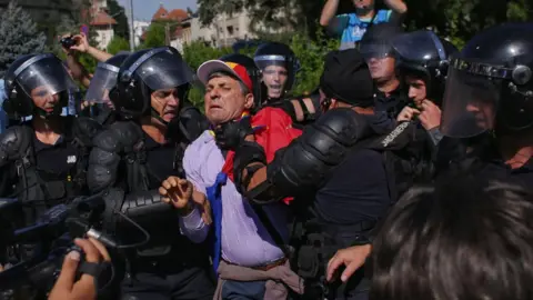 Reuters Police grab a protester in Romania