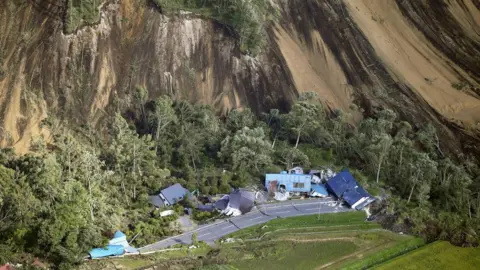 Kyodo/via Reuters Houses destroyed by a large mudslide