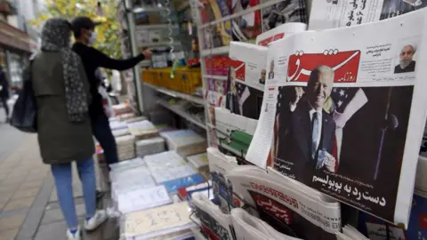 EPA A copy of Iranian daily newspaper Shargh, with a picture of US president-elect Joe Biden and headline "No to populism", on display at a kiosk in Tehran, Iran (8 November 2020)