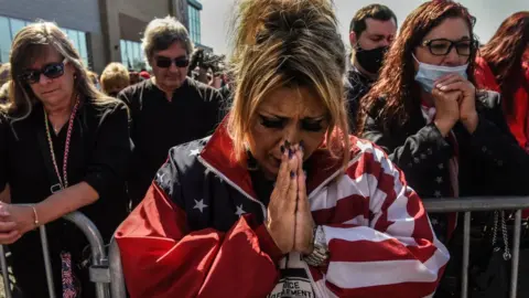 Getty Images Daniela Taormina prays during a pro-Trump rally on October 3, 2020 in the borough of Staten Island in New York City.