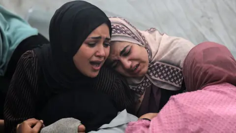 NurPhoto via Getty Images Women at Al-Aqsa hospital in central Gaza mourn their loved ones killed in what Hamas was an Israeli strike on the Al-Maghazi refugee camp last Sunday. Photo: 25 December 2023