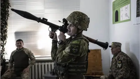 Getty Images A Ukrainian volunteer receives military training in Kyiv in October 2022