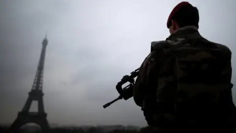 Reuters A French soldier patrols near the Eiffel Tower as part of the "Sentinelle" security plan in Paris on 3 May