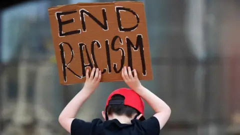 Getty Images A child hold an 'end racism' sign