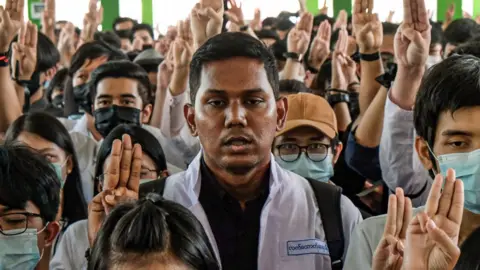 Getty Images Medical students hold up the three finger salute at the funeral of Khant Nyar Hein in Yangon, Myanmar on March 16, 2021