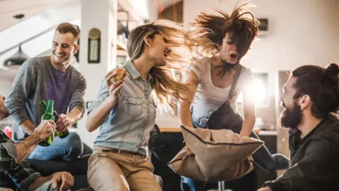 Getty Images Young people having a house party.