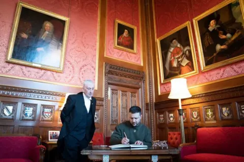 PA Media Speaker of the House of Commons with Ukrainian President Volodymyr Zelensky signing the guestbook at Speaker's House in the Palace of Westminster.