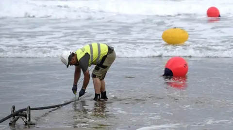 Getty Images A technician works on a undersea fibre optic cable at Arrietara beach near the Spanish Basque village of Sopelana