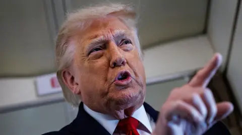 Close up shot of Trump stood pointing while speaking to reporters on Air Force One