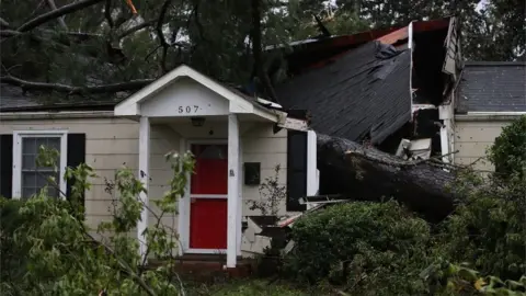 Getty Images A home is damaged after a large tree fell on it