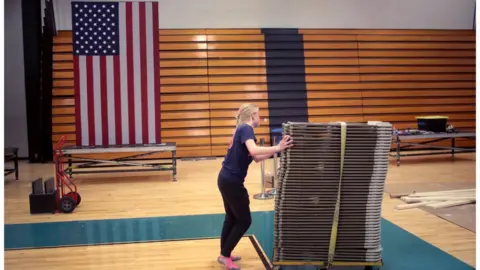 Getty Images A volunteer stacks up chairs at a campaign site in Ohio, which is delaying its 17 March primary contest