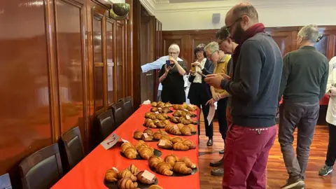 Croissants laid out on a table at a competition with judge Thierry Loussakoueno