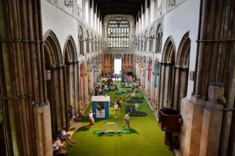 Getty Images people play golf in ROchester Cathedral