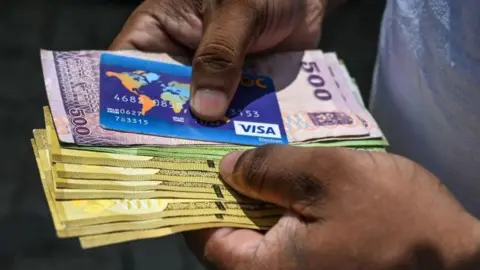 Getty Images A customer queues at a state bank in Colombo in Sri Lanka.