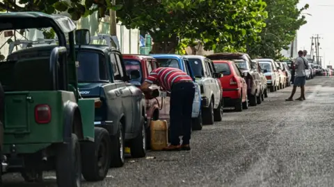 Getty Images Drivers queue to get fuel near a gas station in Havana on 24 April 2023