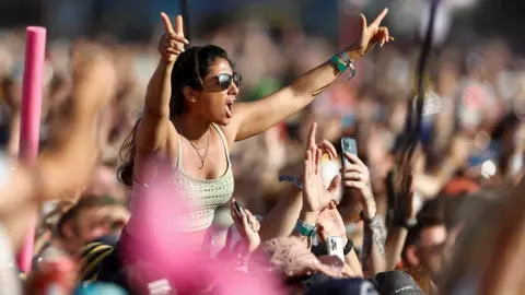 A woman celebrates in the crowd at Glastonbury