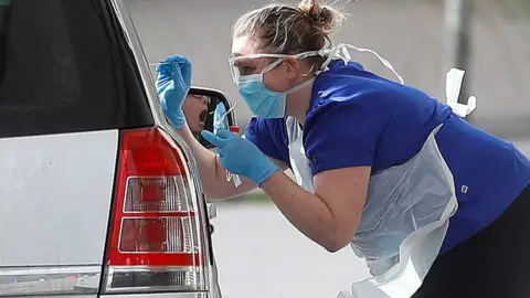 Reuters Medical staff at an NHS drive through coronavirus disease (COVID-19) testing facility in the car park of Chessington World of Adventures as the spread of the coronavirus disease (COVID-19) continues, Chessington,