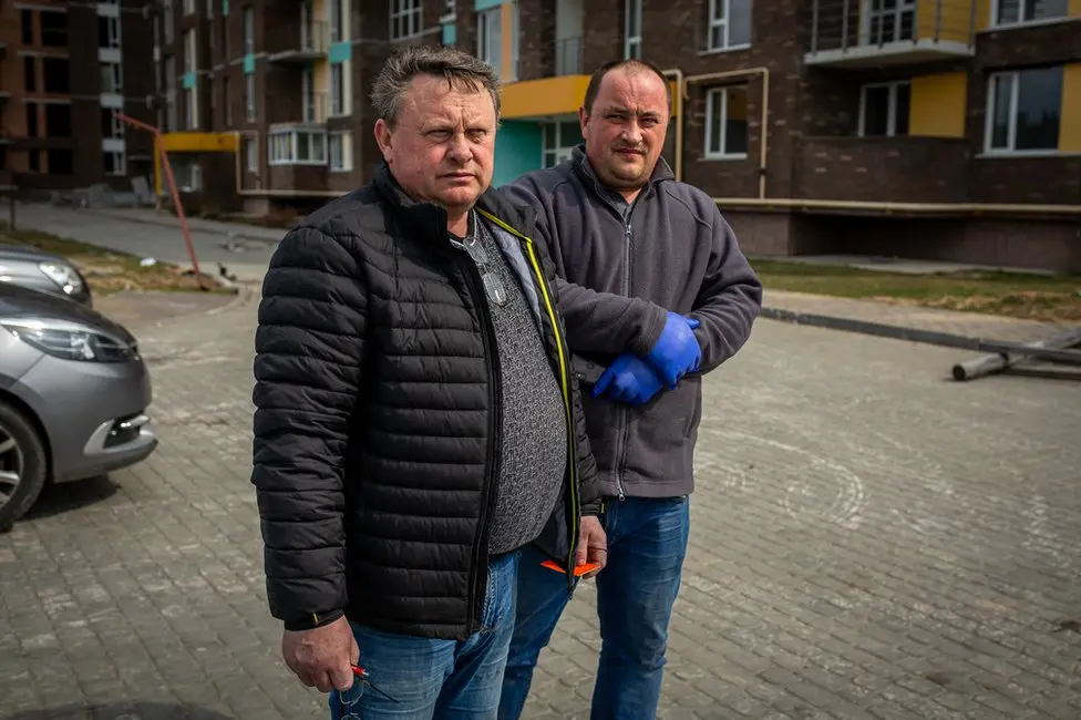 BBC Volodymyr and Serhiy waiting for the van that collects the bodies. Eventually they gave up.