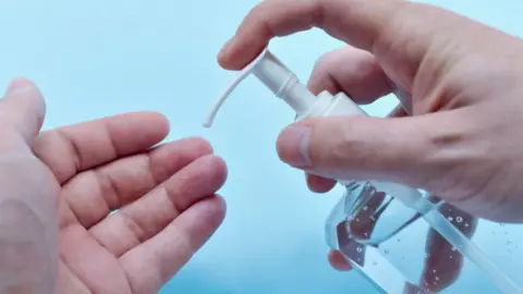 Close up of man using sanitiser