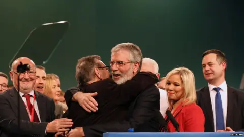 Getty/AFP Gerry Adams surrounded by party colleagues after he announced he was standing down as Sinn Féin leader