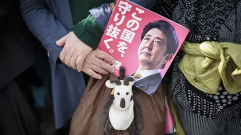 Getty Images Hand holding Shinzo Abe campaign leaflet