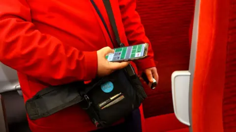 LNER LNER employee holding a ticket machine