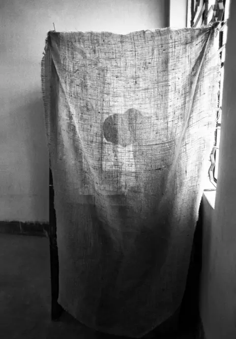 Shahidul Alam Shadow of a woman casting a vote behind a curtain